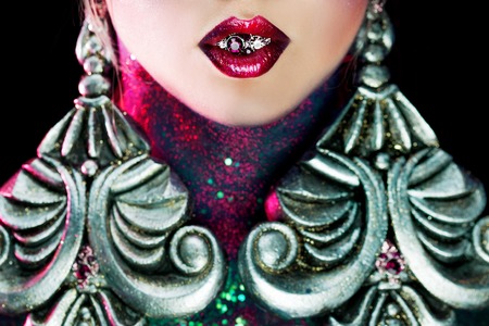Young attractive blonde girl in a bright art-makeup, high hair, body painting. Rhinestones and glitterの写真素材