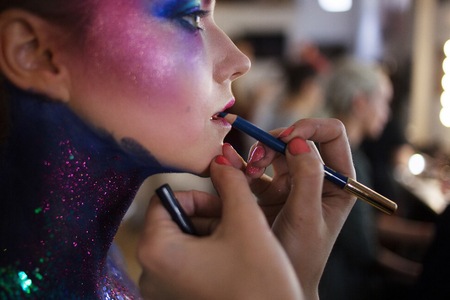 Young attractive blonde girl in a bright art-makeup, high hair, body painting. Rhinestones and glitterの写真素材