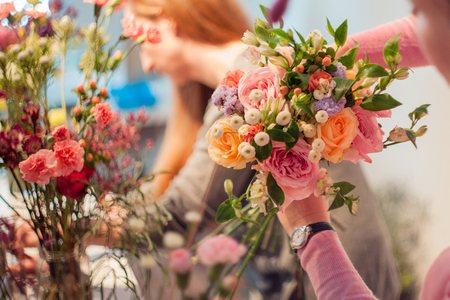 Workshop florist, making bouquets and flower arrangements. Woman collecting a bouquet of roses. Soft focusの写真素材