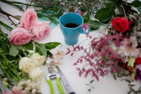 Cup of tea on the table, relax. Workshop florist, table with flowers, still life. Soft focusの写真素材