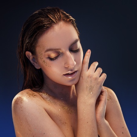 Close up portrait of beautiful woman with creative gold make upの写真素材
