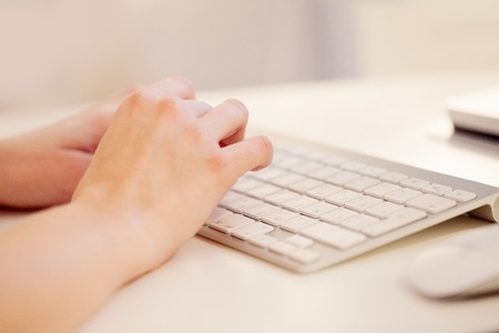 Closeup of a female hands typing on laptop keyboard in the officeの写真素材