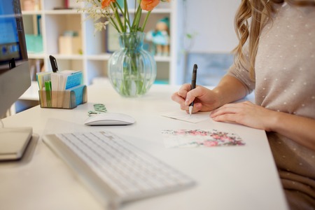 Young businesswoman sitting at desk and working. Beautiful woman signed cardの写真素材