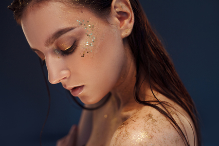 Close up portrait of beautiful woman with creative gold make upの写真素材