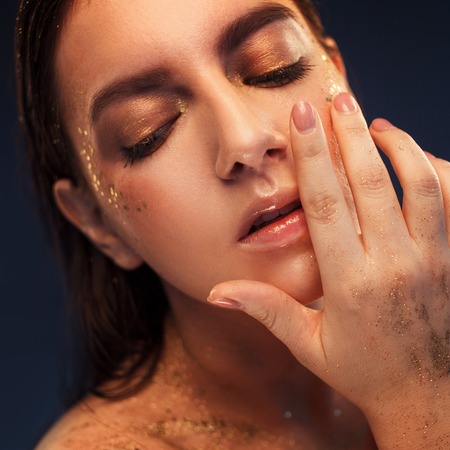 Close up portrait of beautiful woman with creative gold make upの写真素材