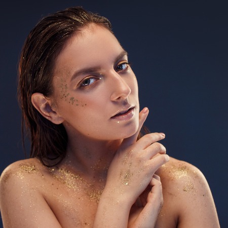 Close up portrait of beautiful woman with creative gold make upの写真素材