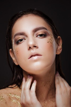 Close up portrait of beautiful woman with creative gold make upの写真素材