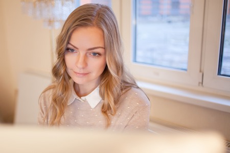 Young businesswoman sitting at desk and working. Beautiful woman and her workplaceの写真素材