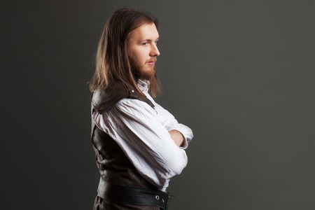Handsome male Steam punk in a leather vest. Retro man portrait over gray background.の写真素材