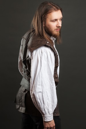 Handsome male Steam punk in a leather vest. Retro man portrait over gray background.
