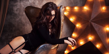 Delightful woman. Sexy brunette girl in the belt, Studio portrait