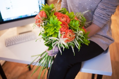 Flower delivery to the office. Young woman holding beautiful bouquet