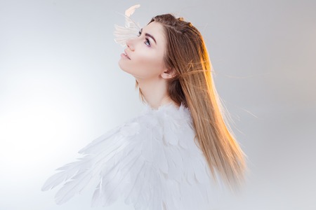 Young, wonderful blonde girl in the image of an angel with white wings.の写真素材