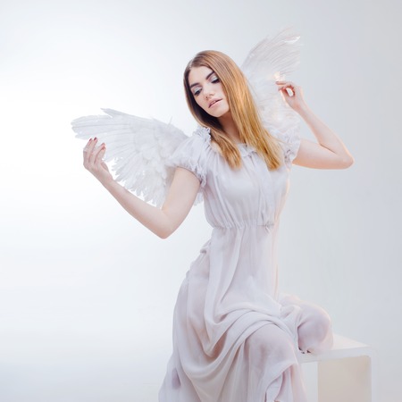Young, wonderful blonde girl in the image of an angel with white wings.の写真素材