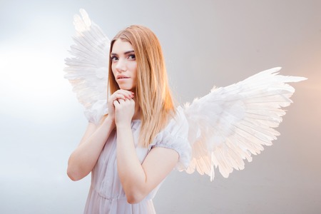 Young and wonderful blonde girl in the image of an angel with white wings.の写真素材