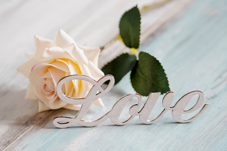 White rose with love on a blue wooden backgroundの写真素材