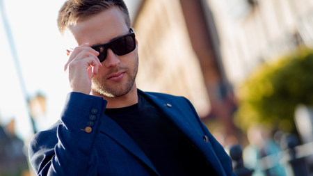 Trendy guy with glasses in the street. Portrait on the background of the cityの写真素材