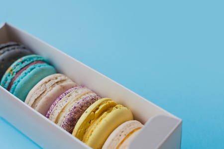 Lot of beautiful macarons. View from the top. In box on a blue backgroundの写真素材