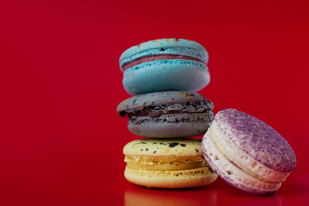 Macarons on red background. Three in a column, one nearの写真素材