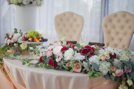 Table of the bride and groom in the restaurant. Wedding decor, flowersの写真素材