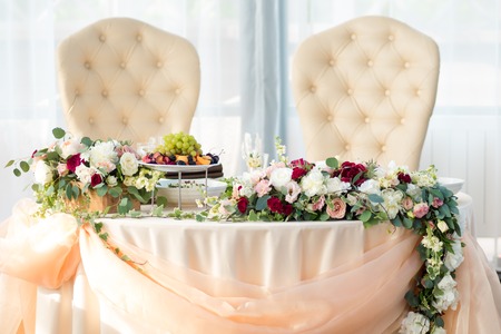 Table of the bride and groom in the restaurant. Wedding decor, flowersの写真素材