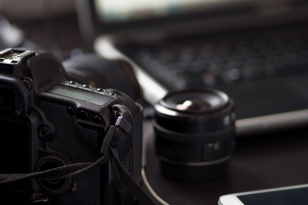 Work table of photographer, camera and lens, laptop.の写真素材