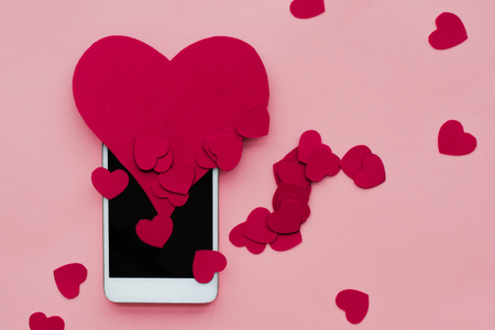 Many hearts and smartphone. The concept to like in social networks or Dating app. pink backgroundの写真素材