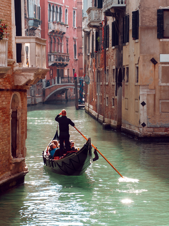 VENICE, ITALY - OCTOBER 8 , 2017: Gondolier floats on the narrow channel in Venice, Italyのeditorial素材