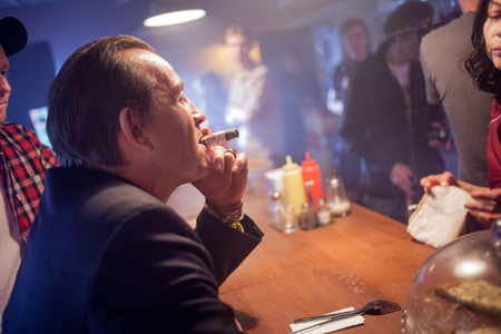 SAINT PETERSBURG, RUSSIA - JULY 22, 2017: Film Crew On Location with 4K Camera Cinematographer at 80s style cafe.のeditorial素材