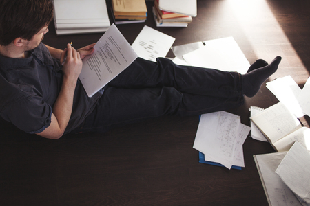 Young male entrepreneur makes brainstorming sitting on the floor in the apartmentの写真素材