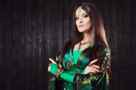 Beautiful girl in green dress dancing Oriental danceの写真素材