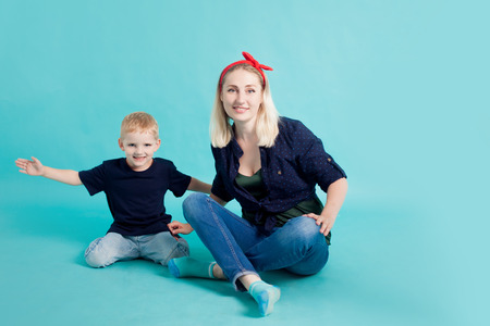 Mom and sons, portrait on blue background. A large and cheerful familyの写真素材