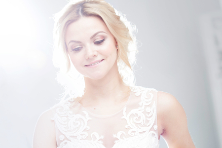 Portrait of a beautiful girl in a wedding dress. Bride in a luxurious dress on a white backgroundの写真素材