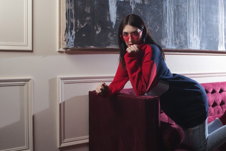 trendy young woman ia red hoodies. Portrait in fashionable interior.の写真素材