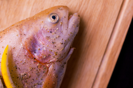 Raw fresh salmon, seasoned with lemon and spices, pickle. On wooden cutting Boardの写真素材