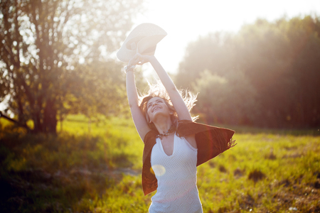 Cute charming girl in summer in the field. Young woman is happy and feels free, outdoorsの写真素材