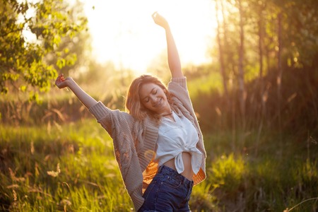 Cute charming girl in summer in the field. Young woman is happy and feels free, outdoorsの写真素材