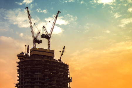 Construction of high-rise building. Construction cranes and skyscraper in process. Horizontal framing, copy spaceの写真素材
