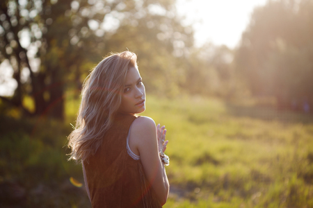 Cute charming girl in summer in the field. Young woman is happy and feels free, outdoorsの写真素材