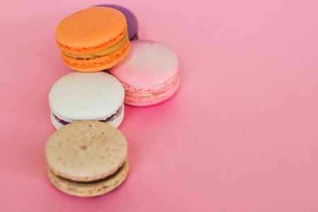 Set of colorful French macaroni cakes. Sweet almond cookies with different flavors. Free space and pink backgroundの写真素材