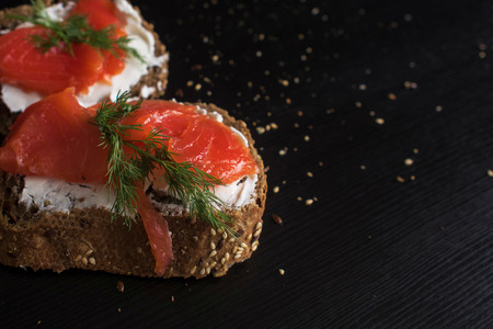 Sandwich with salmon and cream cheese. On a piece of rye multi-grain bread. Close-up copy space on...