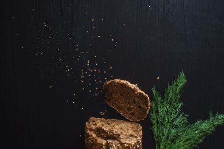 Loaf of multi-grain bread, cut into sandwiches. Close-up, free space for text. Black background