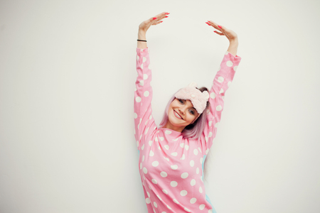 portrait of cute young woman in pajamas and sleep mask, stretches. Woke up in the morning, charge of vivacityの写真素材