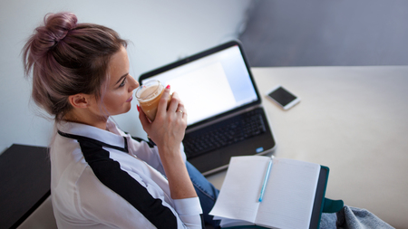 Young freelancer drink coffee and think about work. blogger or student, working space on the couch.