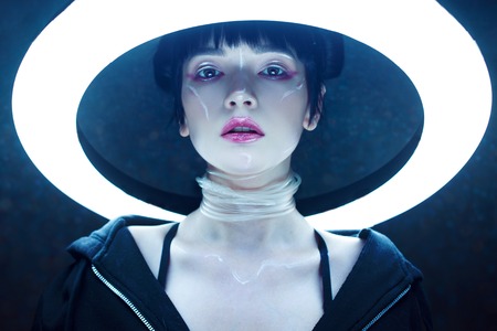 Cyber girl. Beautiful young woman, futuristic style. Portrait against a glowing circle