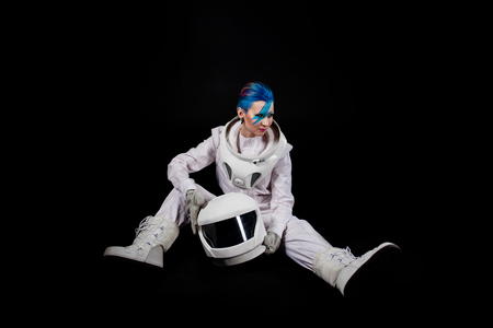 Astronaut on a black background, a young woman with face art in the space suit. sitsの写真素材
