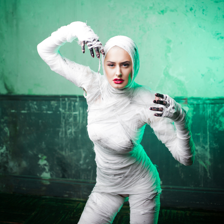Glamorous mummy. Portrait of a young beautiful woman in bandages all over her body. Halloween or...