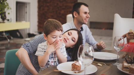 Family dinner. Family receives guests, a festive meeting. family serves table and communicates with each other. Parents children and grandchildren in the house, cake on table.の写真素材