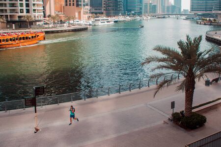 DUBAI, UNITED ARAB EMIRATES - APRIL 25, 2018: Runner on city embankment. Skyscrapers Of Dubaiのeditorial素材