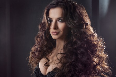 Portrait of a young attractive woman with gorgeous curly hair. Attractive brunette. Close up
